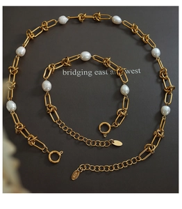 Macro shot of gold-plated link chain jewelry set with freshwater pearls and K18 hallmark