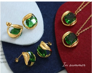 Détail d'un ensemble collier et boucles d'oreilles cristal vert émeraude doré