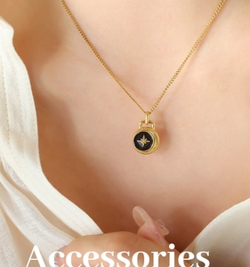 Macro detail of gold-plated starburst medallion necklace with black enamel inlay