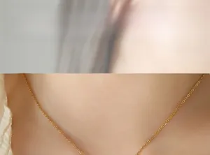 Primo piano di una delicata catena d'oro minimalista sul collo di una modella per un look trendy