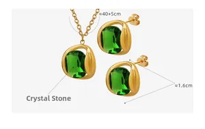 Détail d'une parure dorée avec pendentifs en cristal taille émeraude et chaîne fine