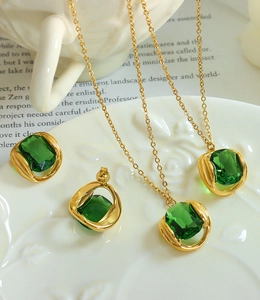 Détail d'un ensemble de bijoux en cristal émeraude avec collier et boucles d'oreilles sur plat