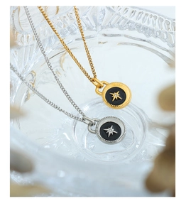 Detailed shot of gold and silver star pendants with black enamel and embedded crystals