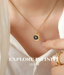 Detailed shot of black enamel star pendant necklace and luxury pearl ring on model