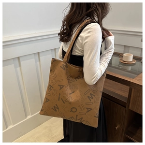 Detail view of large brown leather tote bag with stylish black QIANWEI letter print