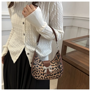 Detail of vintage leopard print half-moon bag with silver metal bow and slim handles