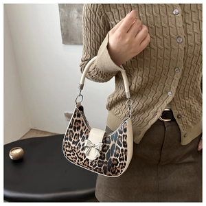 Dettaglio borsa hobo leopardata con fiocco in metallo argento e manico color crema