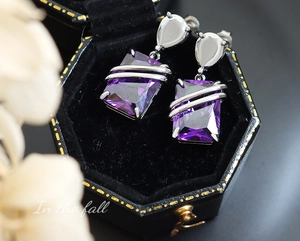 Detailed view of silver square purple zircon earrings in a luxury black velvet gift box