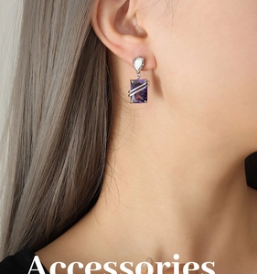 Close-up of rectangular purple zircon earrings with silver drop stone on a model