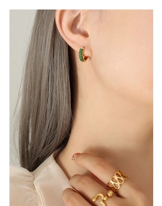 Close-up of 18K gold plated hoop earrings with green zircon and hollow woven gold ring