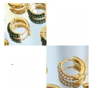 Macro detail of 18K gold plated titanium earrings set with green and white zircon