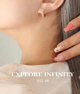 Close-up of gold-plated hoop earrings with micro-pave white zircon on a female model