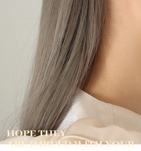 Gros plan de cheveux synthétiques gris cendré lisses avec une texture soyeuse