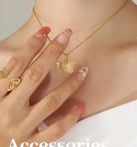 Gros plan sur l'ensemble collier et bague papillon dorés avec zircons portés par un mannequin
