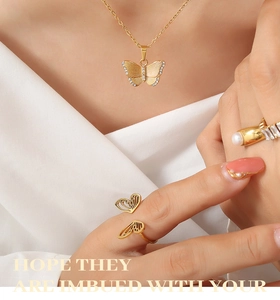 Gros plan d'un ensemble collier papillon doré et bague en perles sur un mannequin femme