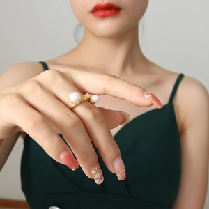 Bague ouverte en acier titane doré avec deux perles blanches et texture torsadée