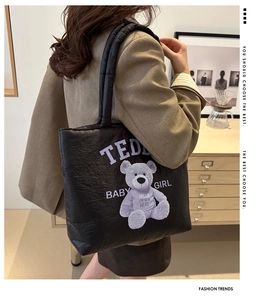 Detail of black quilted tote bag with purple teddy bear print and soft padded handle
