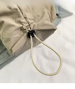 Dettaglio della borsa regolabile in nylon kaki con fibbia a coulisse nera