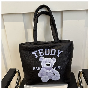 Detail of black quilted tote bag with purple teddy bear print and soft cotton padding