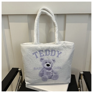 Detail of white quilted tote bag with purple teddy bear print on a metal chair
