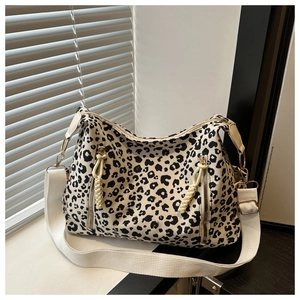 Detail view of canvas leopard print tote bag with dual zippers and wide shoulder strap