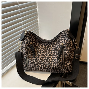 Detailed view of leopard print canvas tote bag featuring dual vertical zipper pockets
