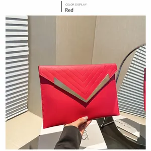 Detail of red chevron stitched clutch bag featuring elegant gold V-shape metal trim