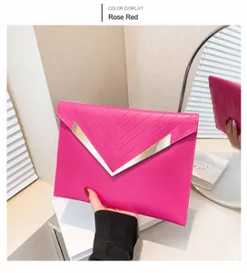Detail showing rose red envelope clutch with V-shaped metal trim and diagonal stitching