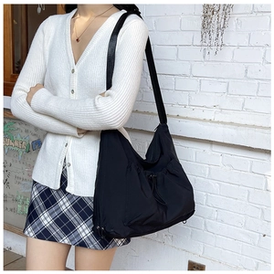 Dettaglio della borsa a tracolla in nylon nero con tasche a coulisse e cinturino largo