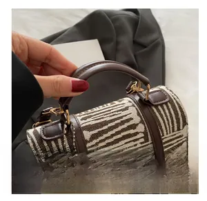 Close-up of jacquard woven fabric and premium brown leather handle on a stylish handbag