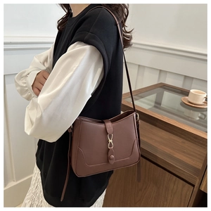 Brown underarm bag with matte leather texture, gold metal ring, and buckle detail
