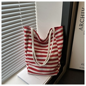 Detail of red and white striped canvas tote bag with cotton rope handle on a windowsill