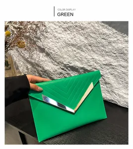 Detail of green sequin clutch with V-shaped stitching and golden metal hardware