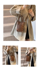 Detailed close-up of leopard print crossbody bag styled with a beige trench coat