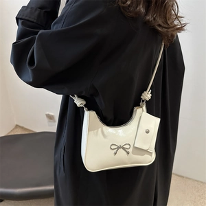 White glossy shoulder bag with silver bow accent and matching mini pouch accessory