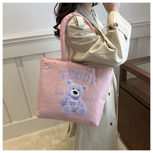 Detailed close-up of pink quilted tote bag featuring purple teddy bear print and soft handles