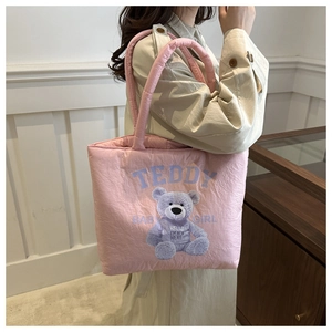 Dettaglio della trama trapuntata della borsa tote rosa con stampa di orsetto viola