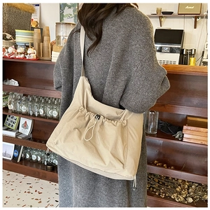 Dettaglio della borsa a vassoio in nylon beige con tasca a coulisse e tracolla