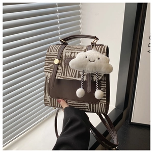 Detail of British style leather and jacquard backpack with plush cloud charm