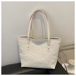 Detail of off-white tote bag showing PU leather pleated texture and metal studs decoration
