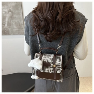 Detail of vintage plaid crossbody bag with canvas leather stitching and cloud charm