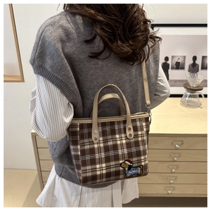 Detail der karierten Segeltuchtasche mit Dackel-Stickerei und Ledergriff im Fokus