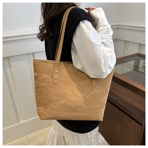 Detail of milk tea tote bag featuring unique pleated texture and gold metal rivets