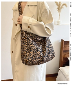 Detailed view of fashionable leopard print canvas tote bag styled with a trench coat