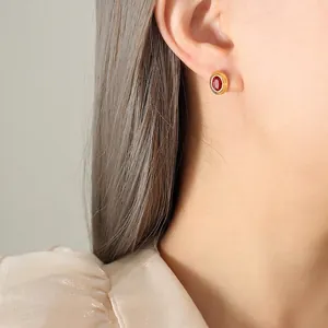 Boucles d'oreilles vintage plaquées or avec zircons rouges ovales portées par un mannequin
