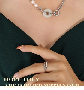 Détail du collier de perles avec pendentif en jade et bague en zircon sur un mannequin