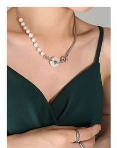 Détail du collier en perles et chaîne argentée avec un pendentif anneau en jade blanc