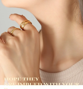 Detailed view of minimalist gold stackable rings worn on a model's hand