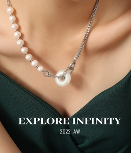 Gros plan du collier en perles et chaîne argentée avec pendentif rond en jade blanc
