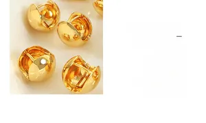 Close-up of polished gold-plated C-shaped earrings with a glossy metallic finish